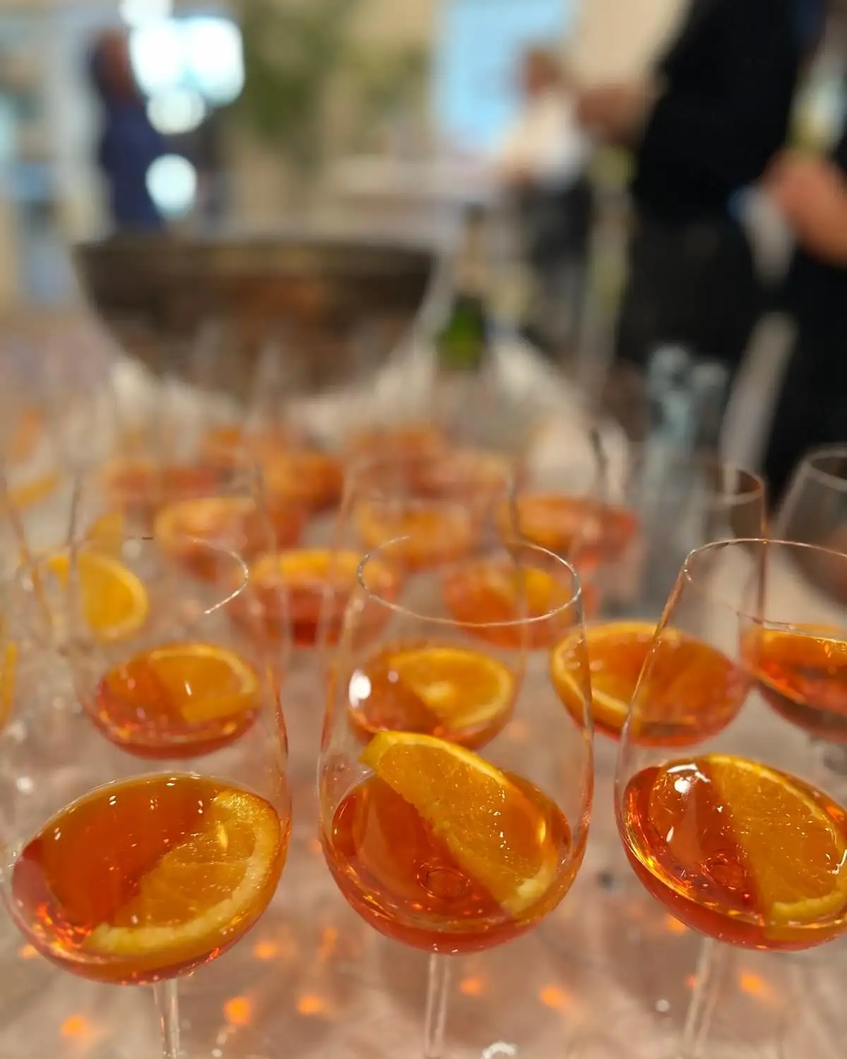 Glasses of Aperol Spritz with a slice of orange at an event