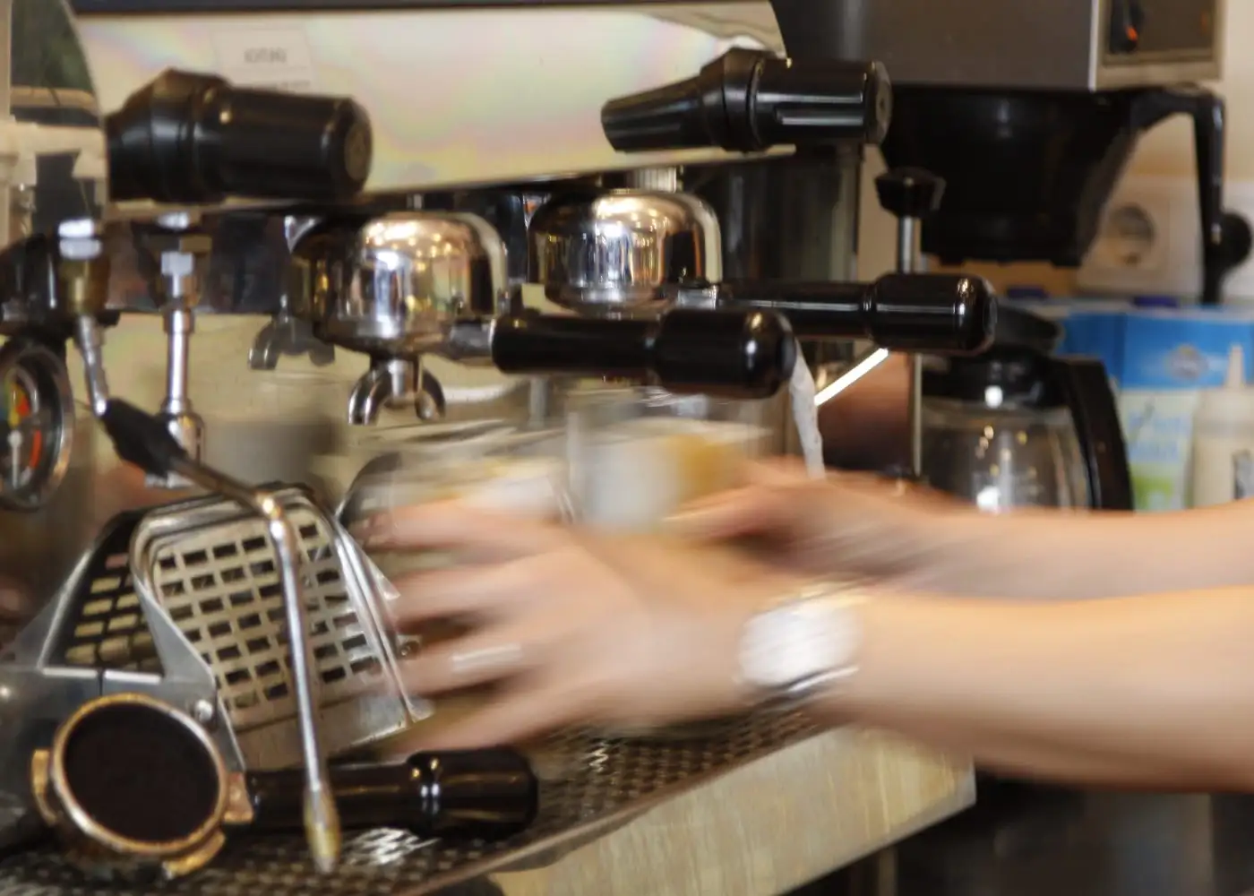 Barista at the espresso machine, hands in motion